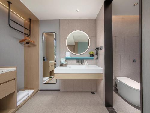 a bathroom with a sink and a mirror at The Liyi Hotel Guangzhou Taikoo Hui Huashi Metro Station Branch in Guangzhou