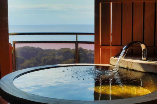 a bathroom with a tub with a water fountain at Rurika in Izu
