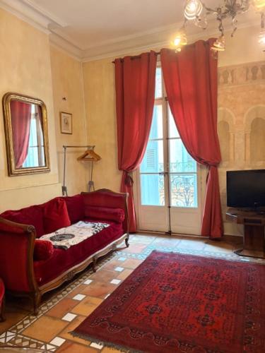 a living room with a red couch and a tv at Bartissol et Maillol in Perpignan