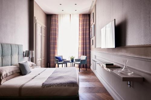 a hotel room with a bed and a window at Le Quattro Dame Luxury Suites in Rome