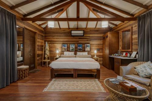 a bedroom with a bed in a room with wooden walls at Mojigao - Eco Resort in Assagao