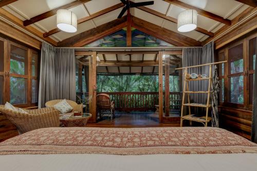 AssagaoにあるMojigao - Eco Resortのベッドと大きな窓のある寝室