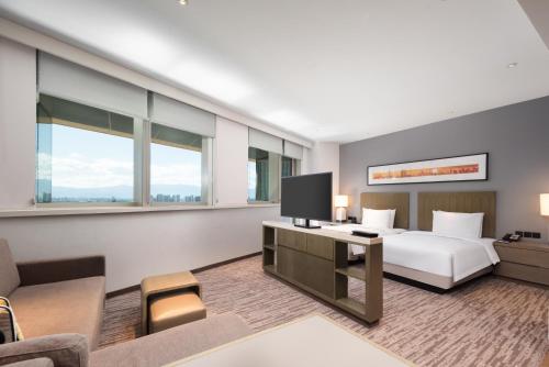 een hotelkamer met een bed en een televisie bij Hyatt House Yinchuan Yuecaicheng in Yinchuan