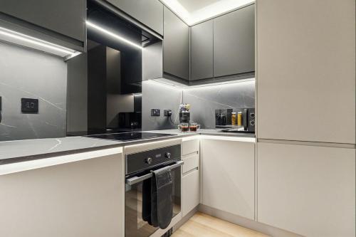 a kitchen with white cabinets and stainless steel appliances at 2BR West End Apartment Near Botanic Gardens in Glasgow