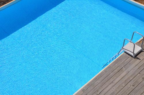 a swimming pool with a chair in front of it at Villa Carolea in Acireale