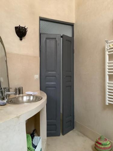梅克内斯里亚德亚姆查旅馆的一间带水槽和蓝色门的浴室