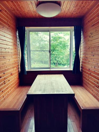 a room with a table and a window at キャンプ&リゾート立山山麓家族旅行村 in Tateyama