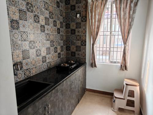 Un baño pequeño con lavabo y ventana. en Suseelagam, en Sīrkāzhi