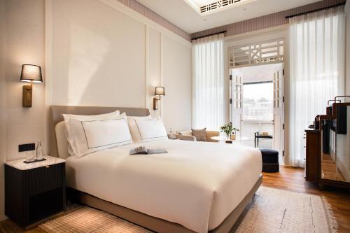 een slaapkamer met een groot wit bed en een woonkamer bij METT Singapore in Singapore