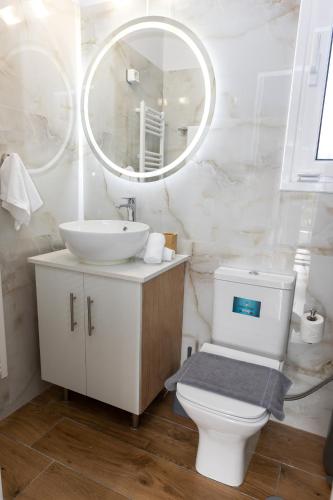 a bathroom with a sink and a toilet and a mirror at Thea Residence Kalavryta in Kalavrita