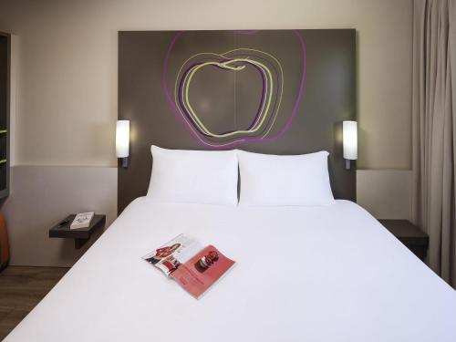 リェイダにあるHotel Ibis Styles Lleida Torrefarreraの壁にハートが描かれたホテルの部屋のベッド