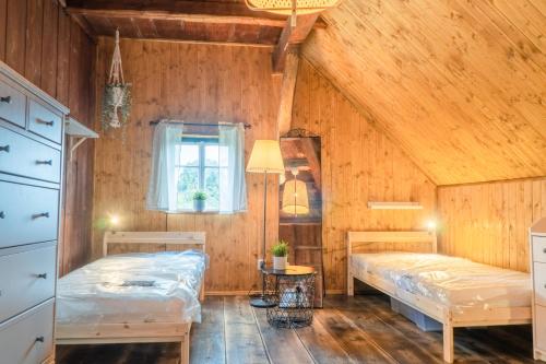 Dos camas en una habitación con paredes de madera. en Chalupa Císařský, en Šluknov