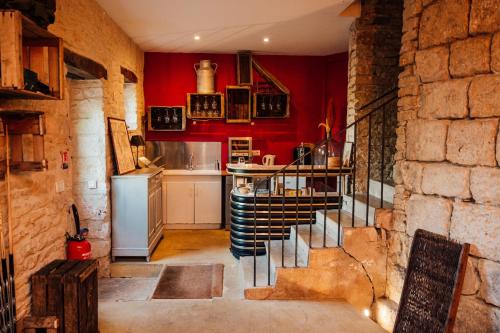 a kitchen with red walls and a staircase in a room at Domaine de Venoise, Château 31 personnes in Noyers-sur-Serein