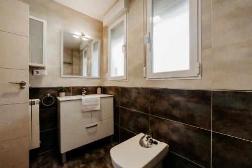 ein Badezimmer mit Toilette und Waschbecken und einem Fenster in der Unterkunft Living Logroño in Logroño