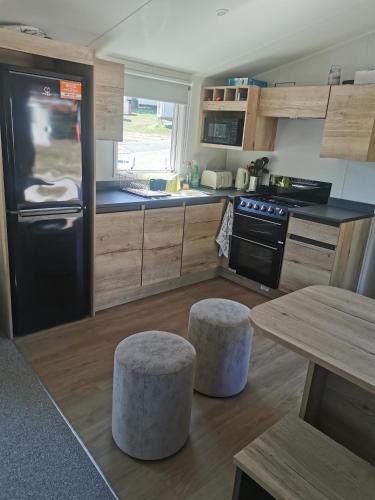 a kitchen with a black refrigerator and a table at Thornesbay holiday park in Isle of Wight
