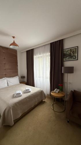 a bedroom with a bed and a chair and a table at Miznah Hotels & Resorts in Bačka Topola