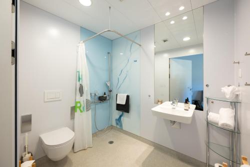 Un baño con ducha, inodoro y lavabo. en Shima-Davos, en Davos
