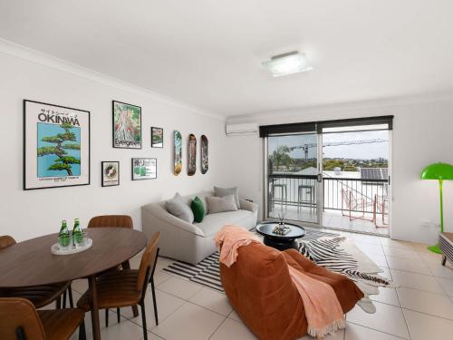 a living room with a couch and a table at Pine Street Apartments Bulimba in Brisbane