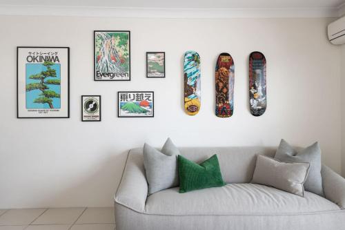 a living room with a couch and four skateboards on a wall at Pine Street Apartments Bulimba in Brisbane