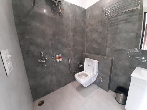 a bathroom with a white toilet in a stall at Shukla Bhawan in Panchkula