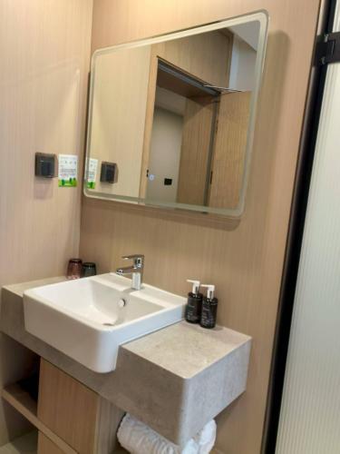 une salle de bain avec un lavabo et un miroir dans l'établissement Beijing Northern Langyue Hotel Financial Street Branch, à Pékin