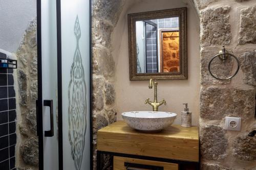 een badkamer met een wastafel en een spiegel bij Katmani Hotel in Mardin