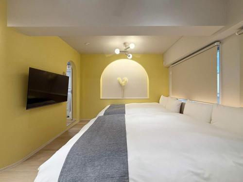 une chambre avec un grand lit et une télévision à écran plat dans l'établissement Clio Matoba by b hotel - Fully Equipped Urban Studio Peaceful Stay, à Ōsukachō