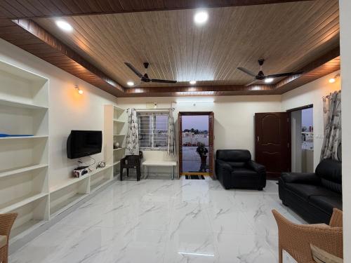 un salon avec un canapé et une télévision dans l'établissement Casa Bianca Penthouse Retreat, à Secunderābād