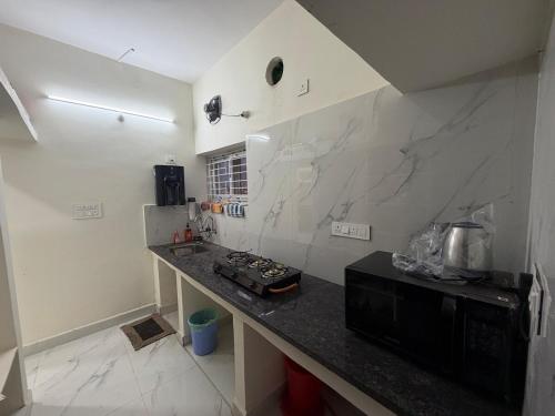 - une cuisine avec un comptoir, une cuisinière et un évier dans l'établissement Casa Bianca Penthouse Retreat, à Secunderābād