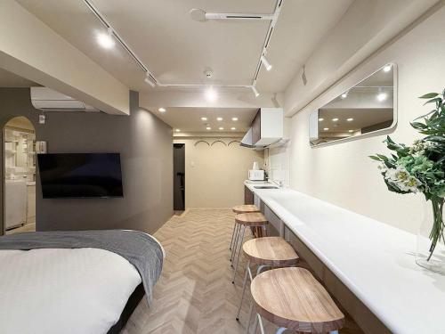 a room with a bed and a bar with stools at Clio Matoba by b hotel - Fully Equipped Studio 10min to Hiroshima Station in Ōsukachō