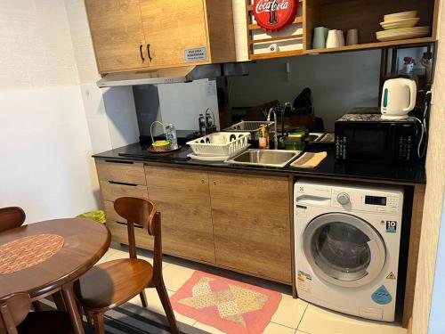een keuken met een spoelbak en een wasmachine bij Timurbay Seafront Kuantan Beach D'Sunset Ombak Samudera in Kuantan