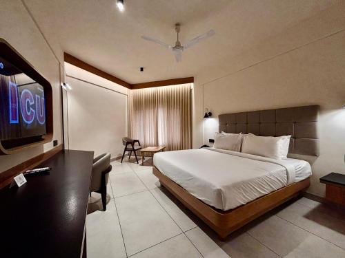 a hotel room with a bed and a flat screen tv at Manuelsons Malabar Palace in Kozhikode