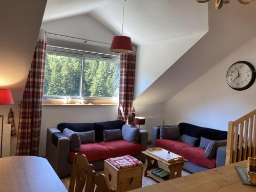 a living room with two couches and a window at T2 avec vue sur les montagnes et wifi in Le Lioran