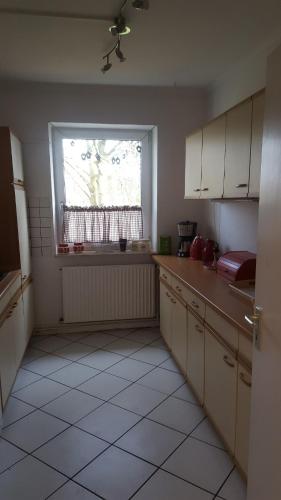 an empty kitchen with a window and a kitchen floor at FerienwohnungHunteblick in Wildeshausen