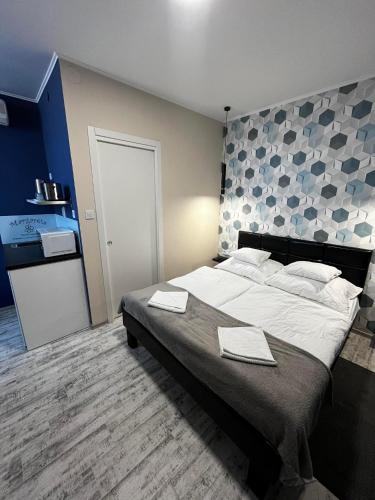 a bedroom with a large bed with towels on it at Margaréta Studió Apartman in Hódmezővásárhely