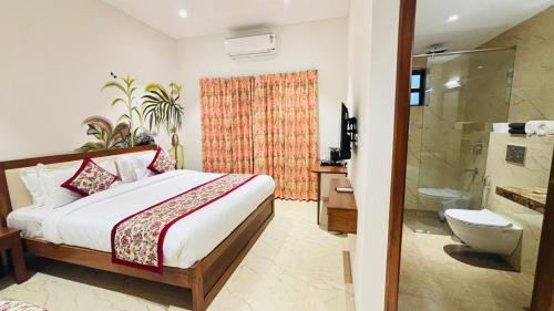 乌代浦MAYA'S MANOR - A Luxury Lake View Boutique Hotel的一间带床的卧室和一间带淋浴的浴室