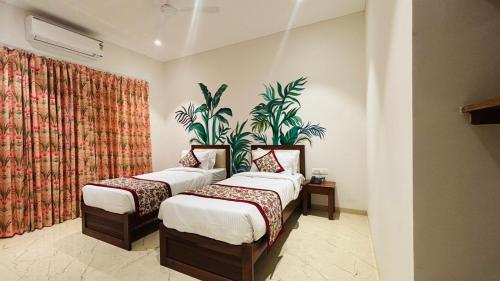 乌代浦MAYA'S MANOR - A Luxury Lake View Boutique Hotel的墙上有植物的房间,有两张床