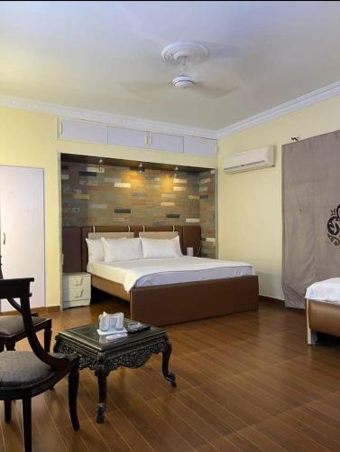 a large bedroom with a large bed and a table at Hotel Exclusive in Dargai