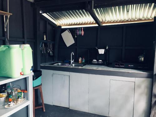 uma cozinha com armários brancos e uma pia em The Valley Home em Taytay