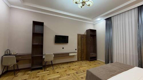 a bedroom with a bed and a desk and a television at Art Dream Hotel in Tashkent