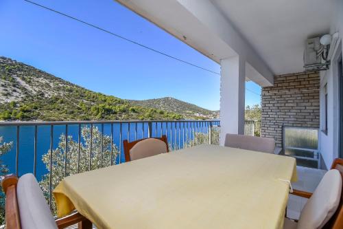 a table and chairs on the balcony of a house at Apartments Ivan in Vinišće