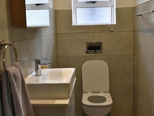 ein Badezimmer mit einer weißen Toilette und einem Waschbecken in der Unterkunft 1 on York Townhouse 3 in George