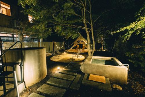 a backyard with a tub and a playground at night at ヴィヒタ 山中湖 in Yamanakako