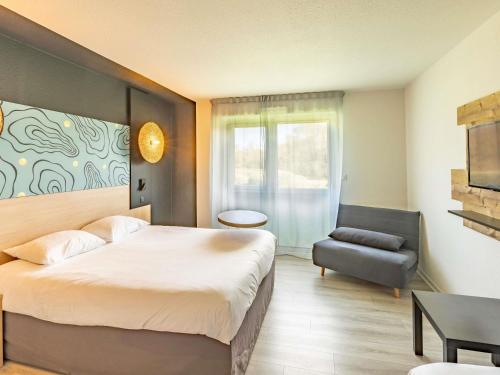 a hotel room with a bed and a chair at ibis Styles Marennes d'Oléron in Marennes