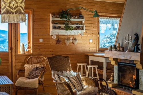 a living room with a fireplace and a table and chairs at Alemiło - uroczy dom z balią i widokiem na Babią Górę in Zawoja
