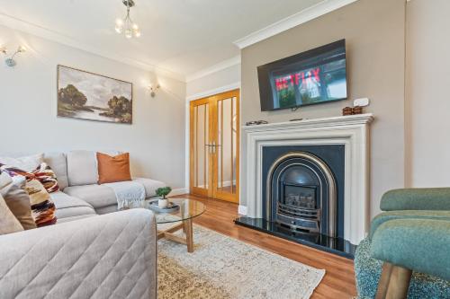 a living room with a fireplace with a tv above it at Luxury Escape Sleeps 7 in Albrighton- 4 Beds 3 Double beds 1 single 2 Mins to M54 RAF Cosford Shifnal Telford Oxley Staffordshire -JLR Wolves Stafford I54 Business Park- 10 Mins to M6- 40 Mins to NEC Regular & Long Work Stays available - Samina- ARZ Stays in Albrighton