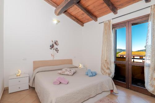TeltiにあるPasigà- Jacuzi privata vicino Olbiaのベッドと大きな窓のある寝室