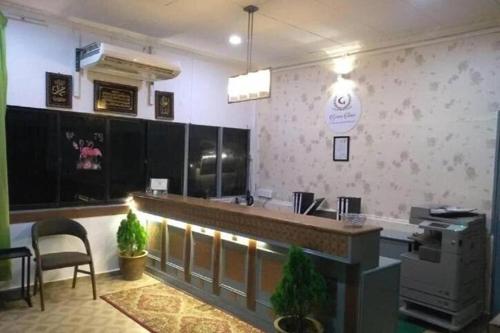 a restaurant with a counter and chairs in a room at Green Town Hotels and Resorts in Port Dickson