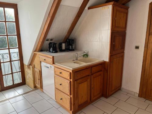 a small kitchen with a sink and a refrigerator at La Closerie de Baneuil in Baneuil