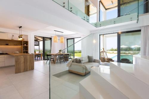 an open kitchen and living room with glass walls at Elegante Villa Mit Beheiztem Pool Und Fantastischer Aussicht in Skouloúfia